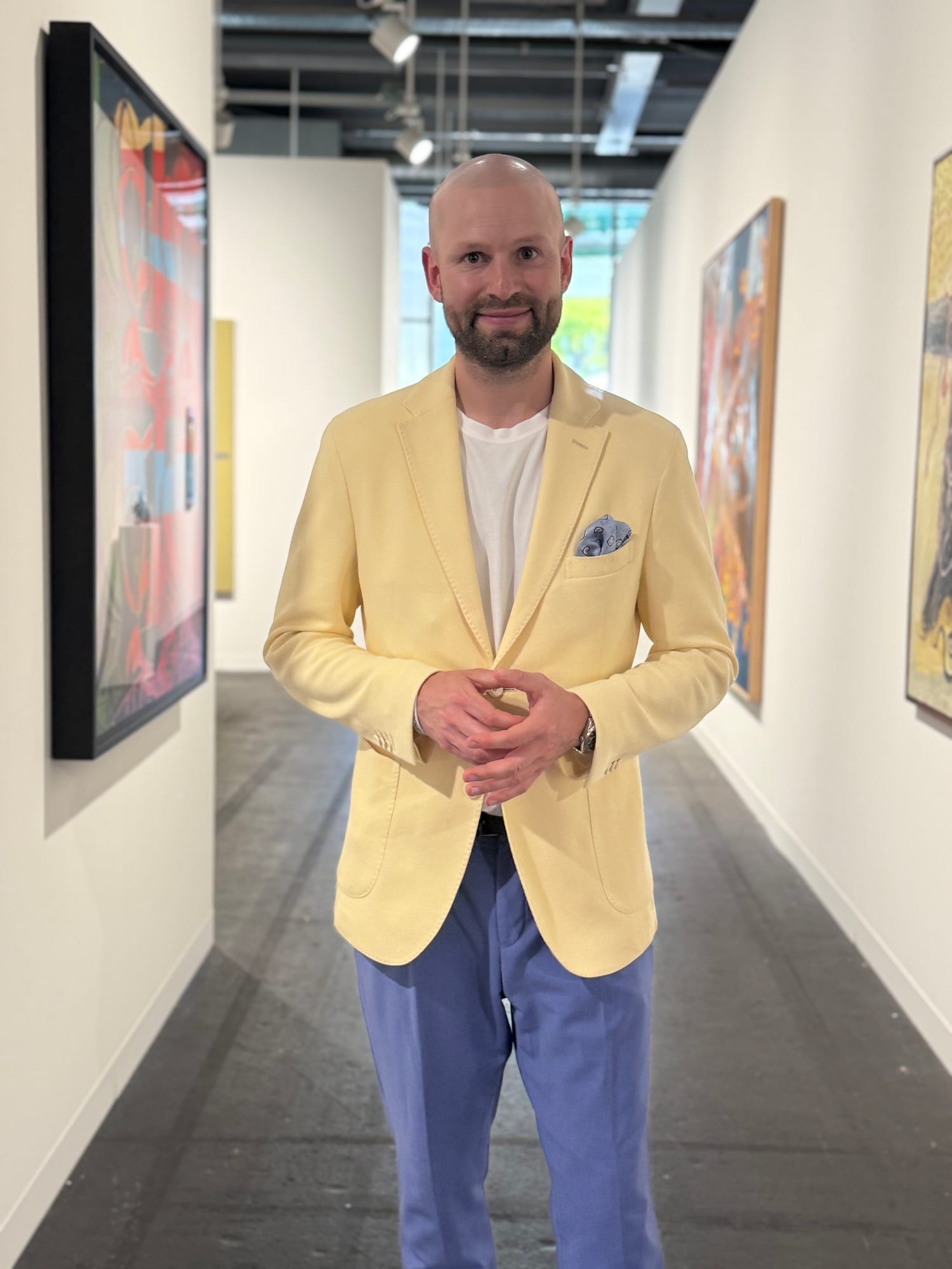 Robert Eckstein in einem hellen Messegang zwischen Kunstwerken.
