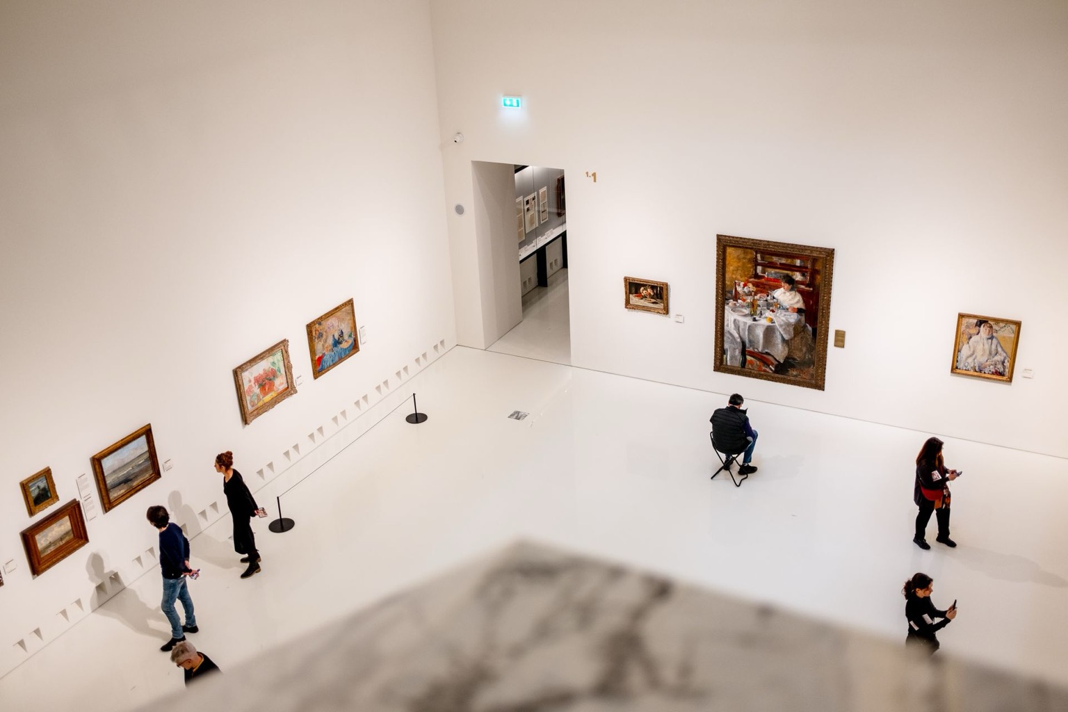 Stockfoto: Besucher betrachten Gemälde in einem hellen Museumssaal