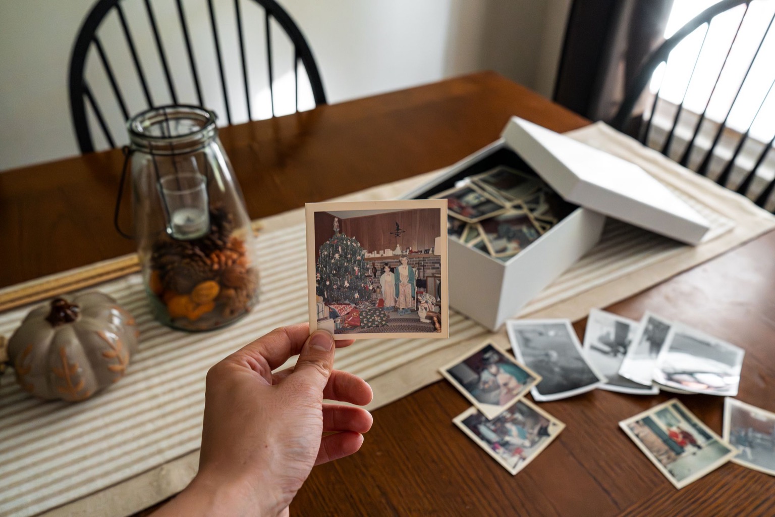 Symbolisches Stockfoto: Eine Hand sortiert alte Familienfotografien.