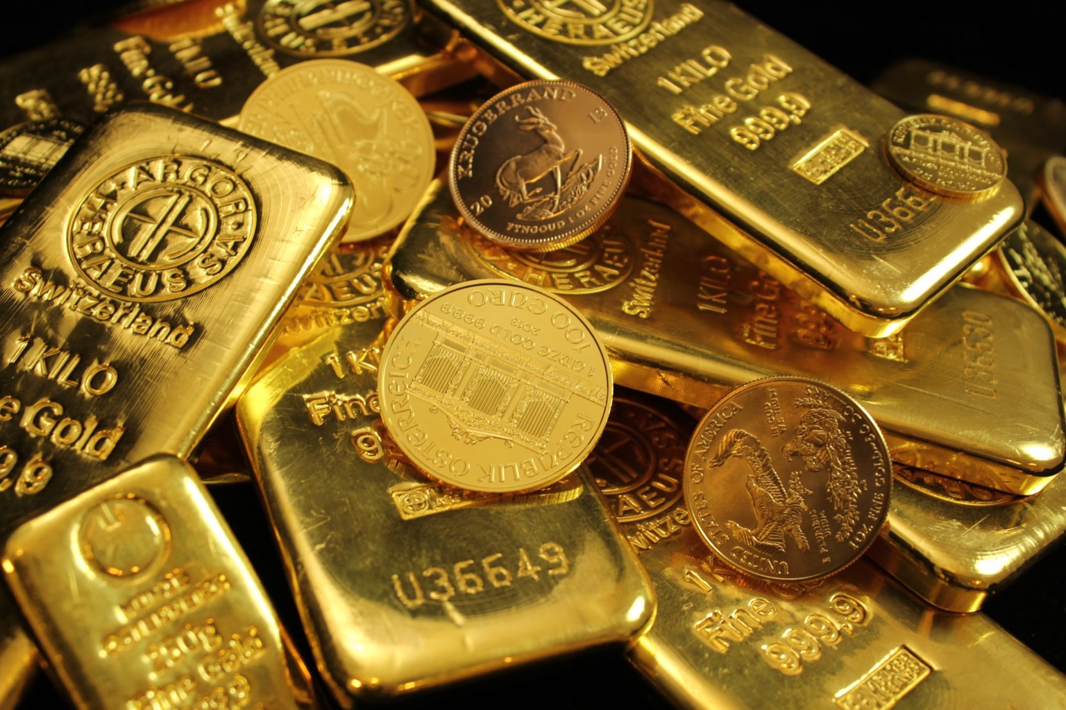 Symbolisches Stockfoto: Goldbarren und Anlagemünzen in Nahaufnahme.