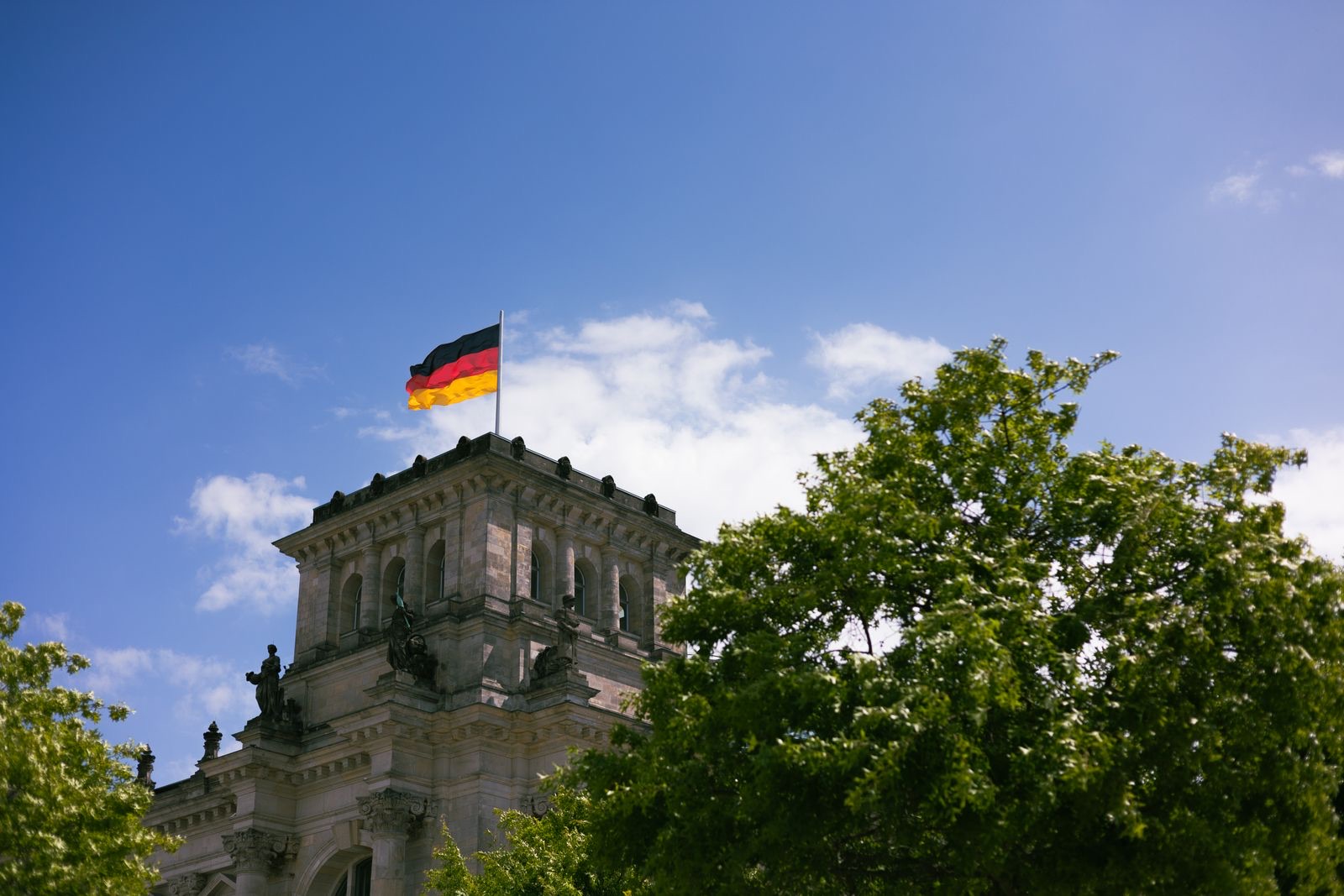 Reichstagsgebäude in Berlin mit deutscher Flagge.