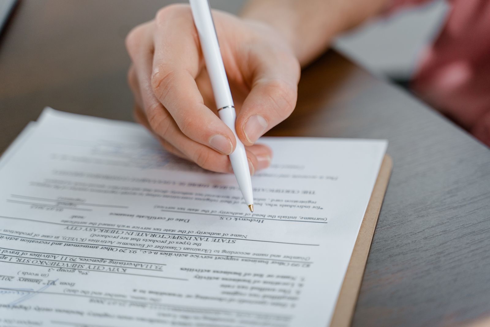 Symbolfoto: Eine Hand unterschreibt ein Dokument mit einem Stift.